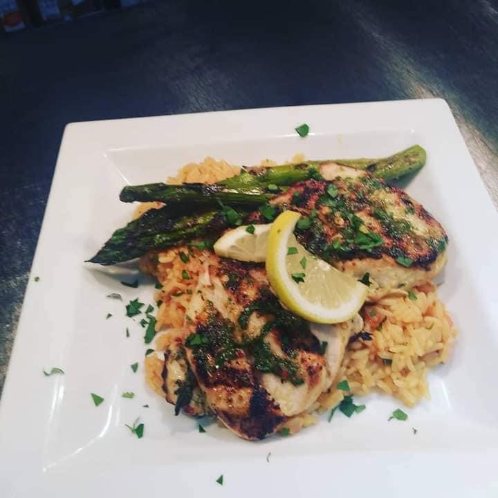 Grilled chicken over seasoned rice with asparagus